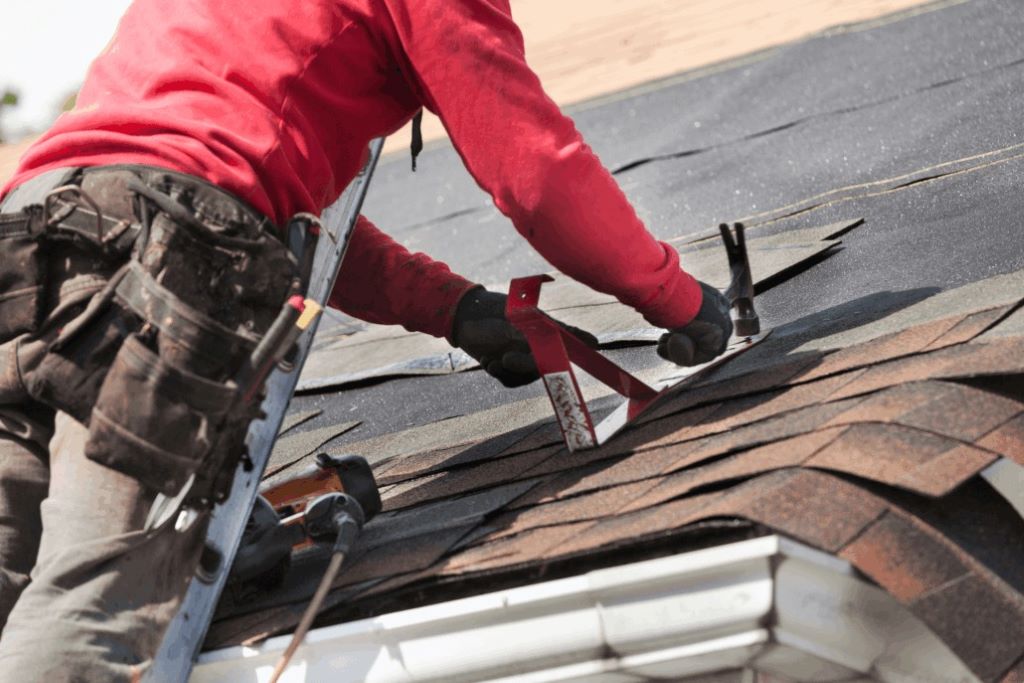 Homeowner attempting DIY roof repair with missing shingles and tools scattered, highlighting costly roof repair mistakes
