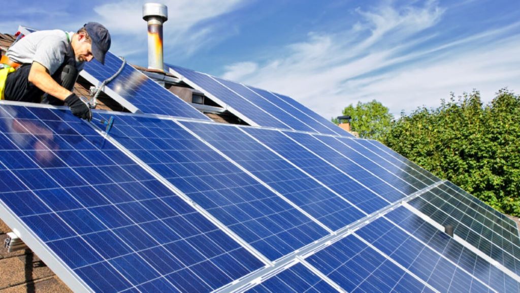 Solar panels being installed on an older residential roof